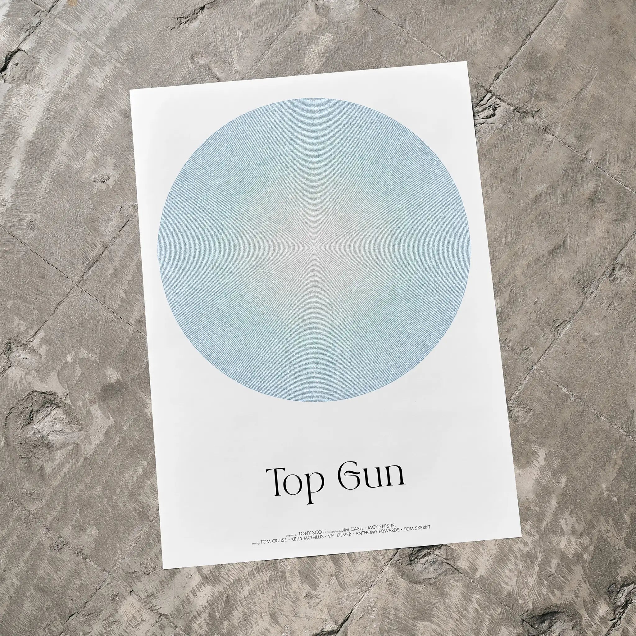 Poster with a blue circle and 'Top Gun' text on a textured gray surface