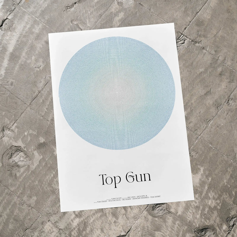 Poster with a blue circle and 'Top Gun' text on a textured gray surface