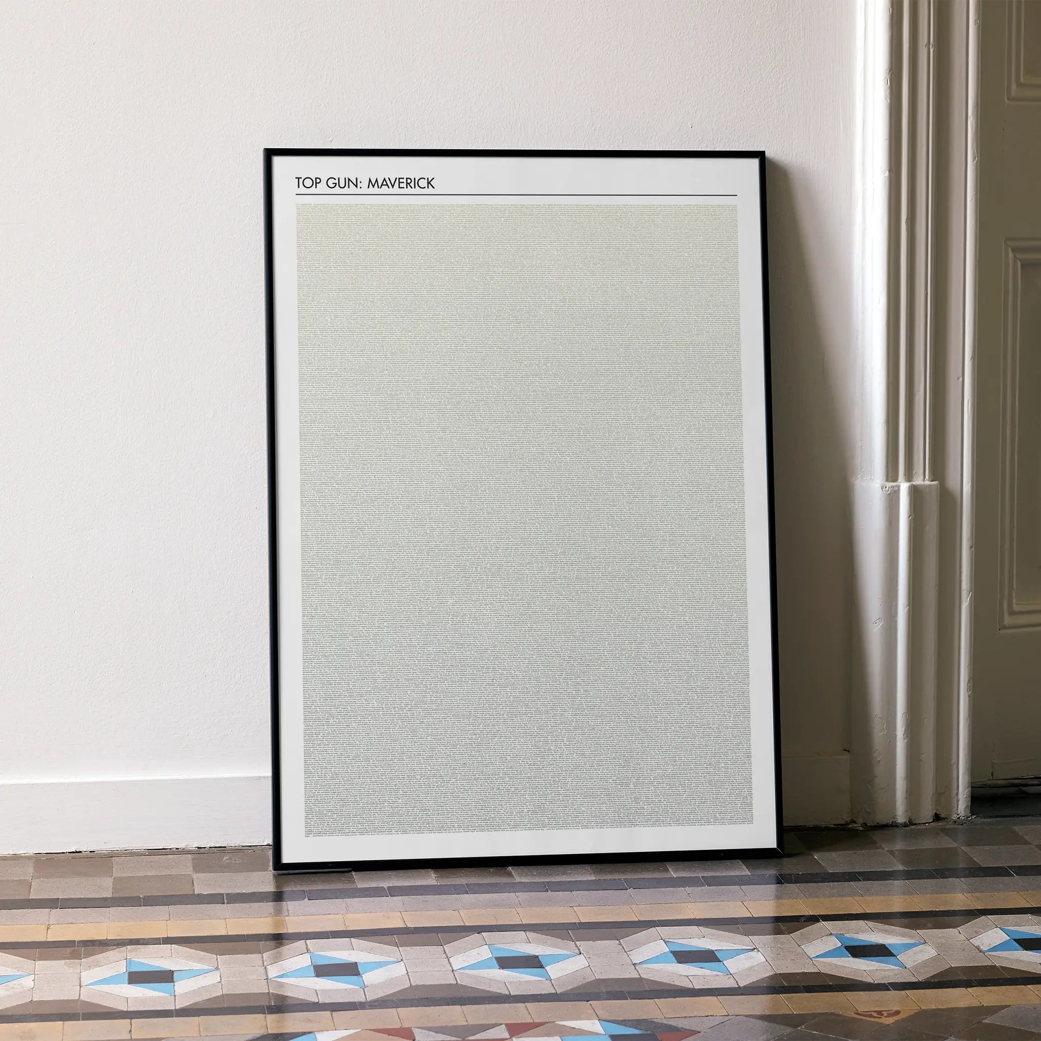 A framed Top Gun: Maverick movie script poster leaning against a wall in a minimalist interior.