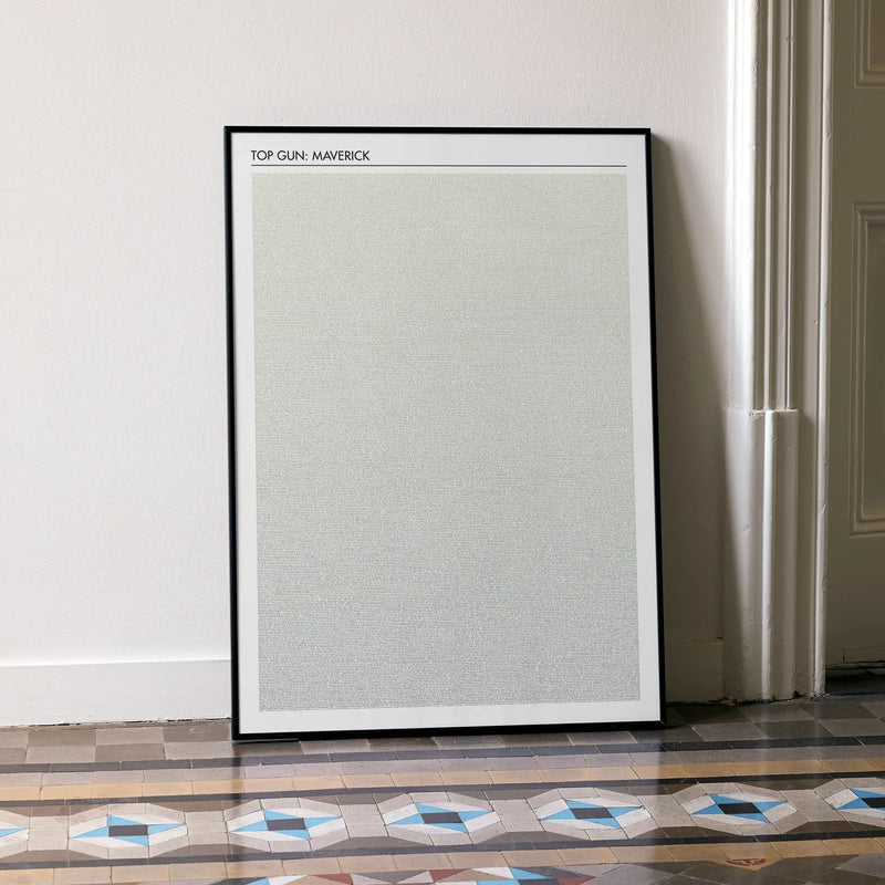 A framed Top Gun: Maverick movie script poster leaning against a wall in a minimalist interior.