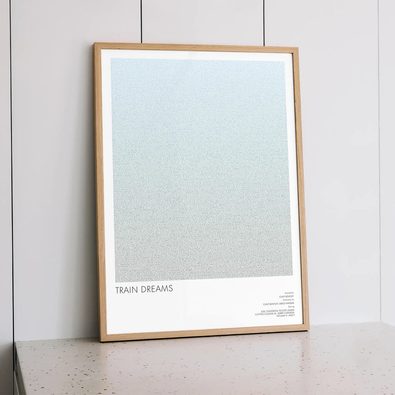 A framed Train Dreams movie script poster styled within a calm interior space.