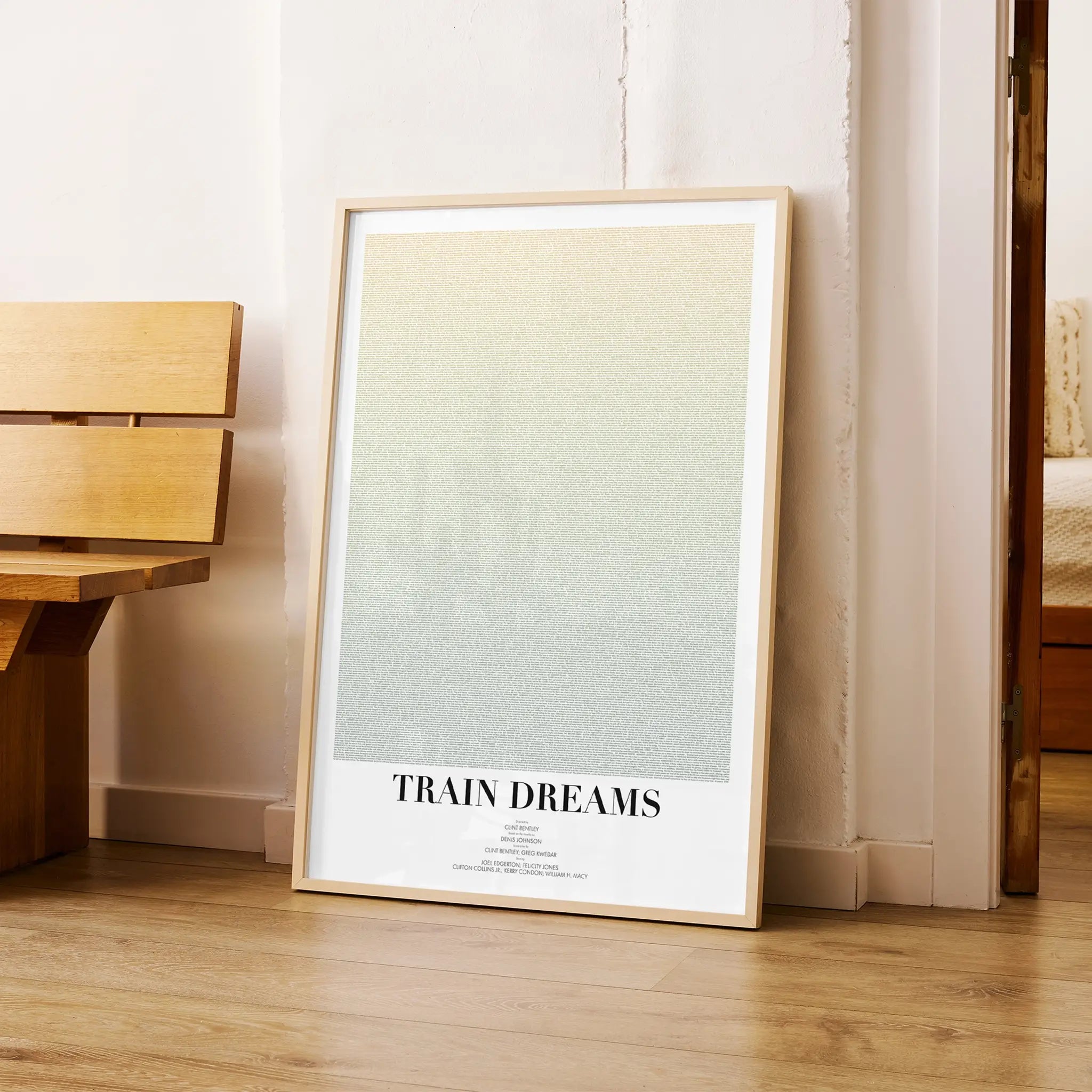 A framed Train Dreams movie script poster arranged in a minimalist interior setting.