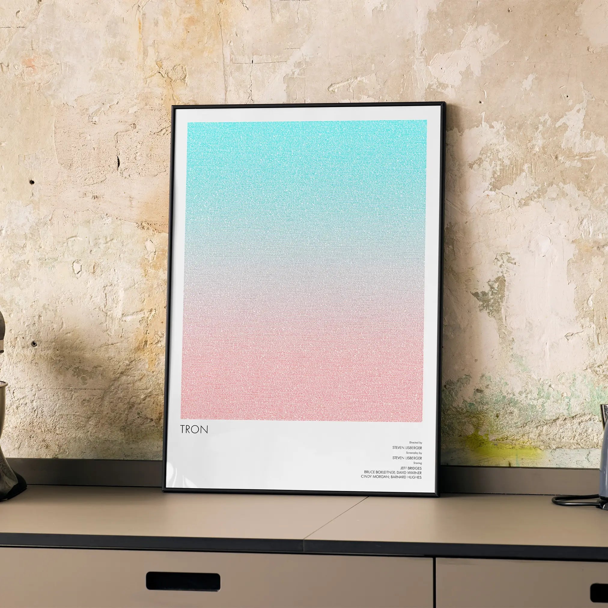 A framed Tron movie script poster displayed on a cabinet in a minimalist interior.