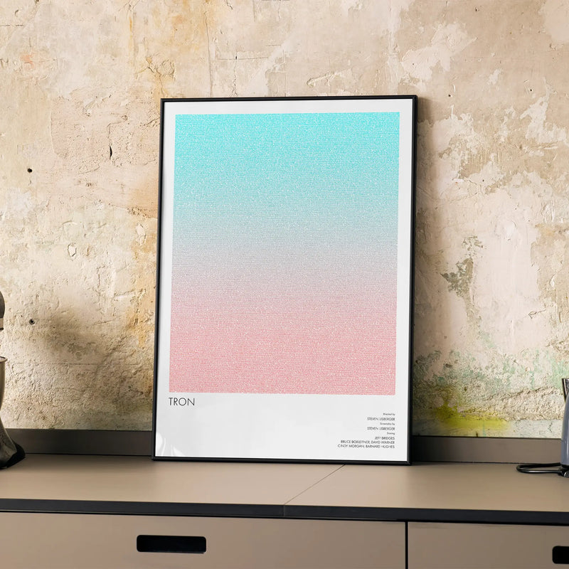 A framed Tron movie script poster displayed on a cabinet in a minimalist interior.
