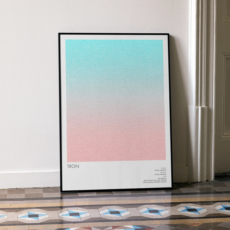 A framed Tron movie script poster leaning against a wall in a minimalist interior.