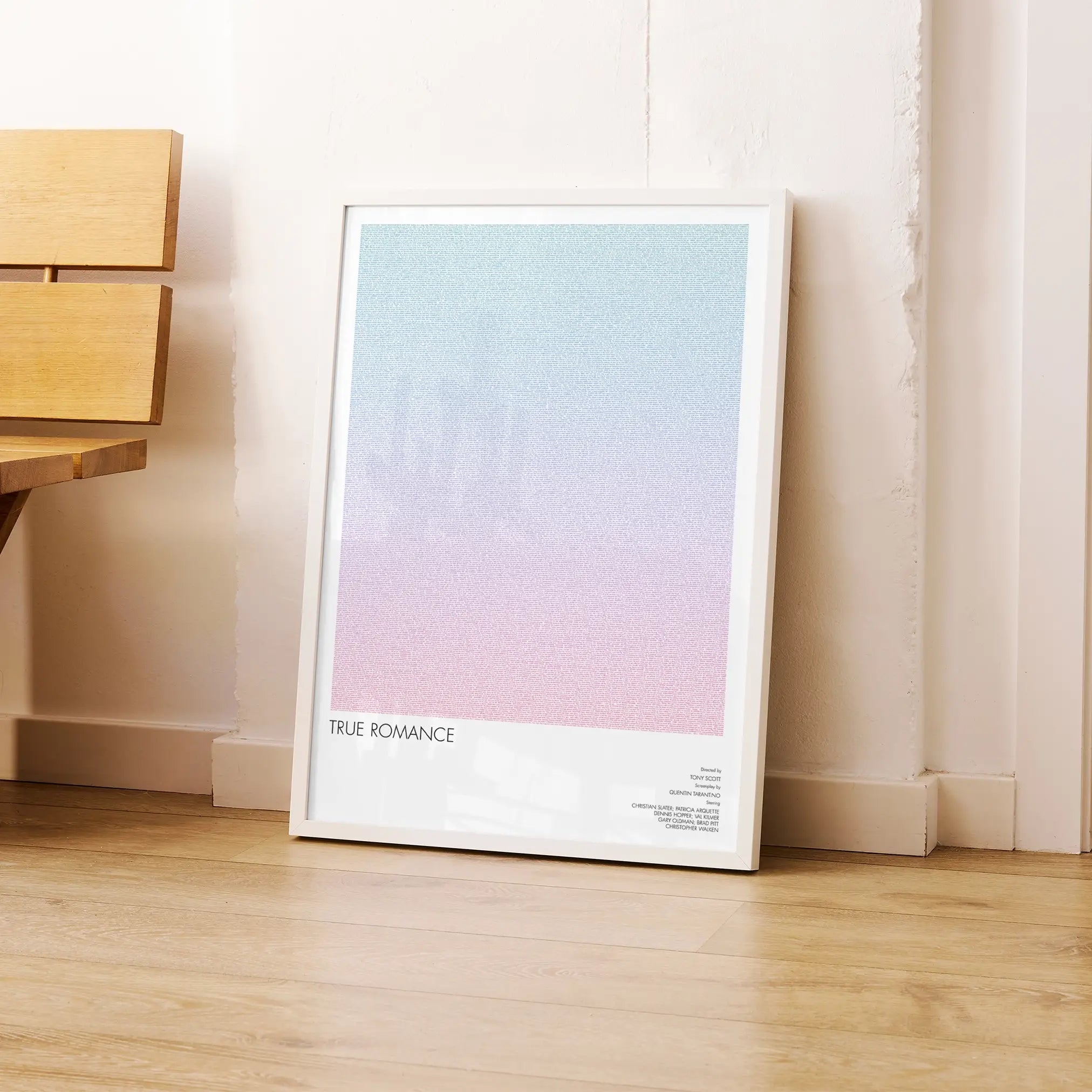 A framed True Romance movie script poster leaning against a wall in a modern interior.