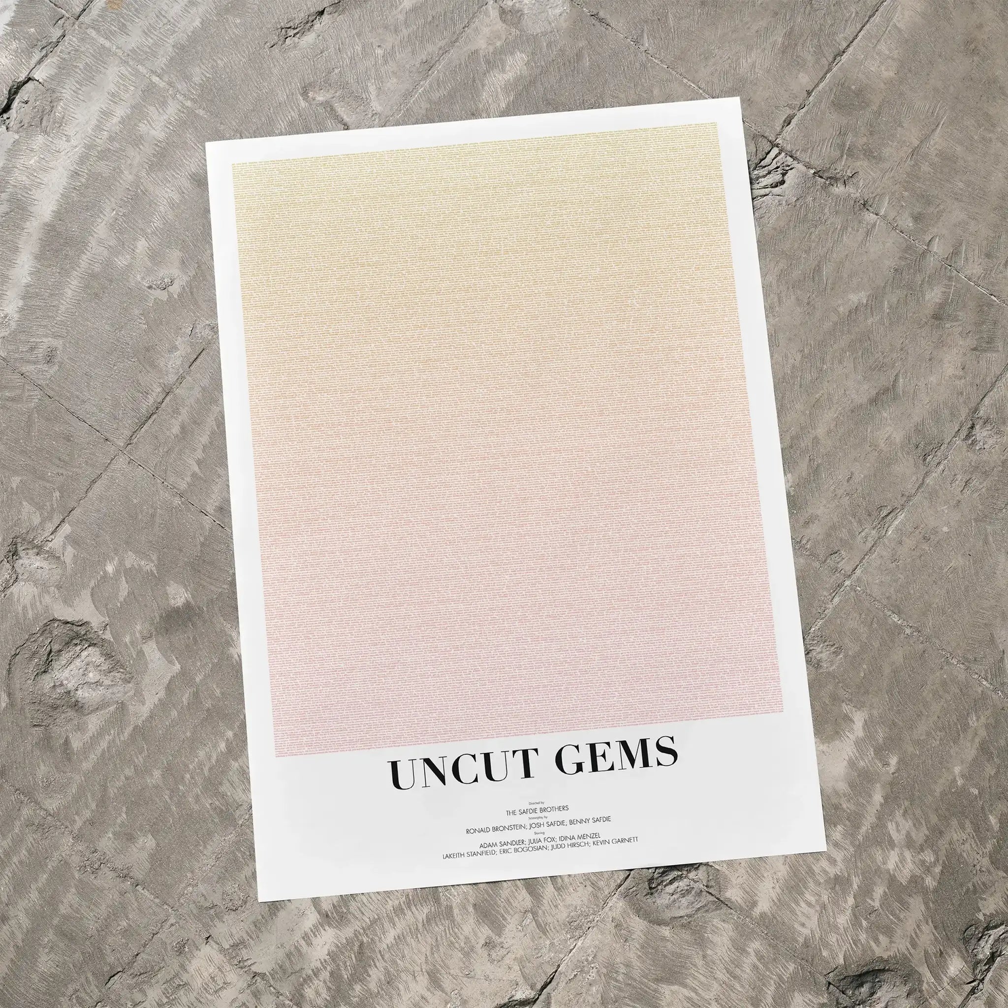 A Uncut Gems movie script poster laid flat on a textured floor surface.
