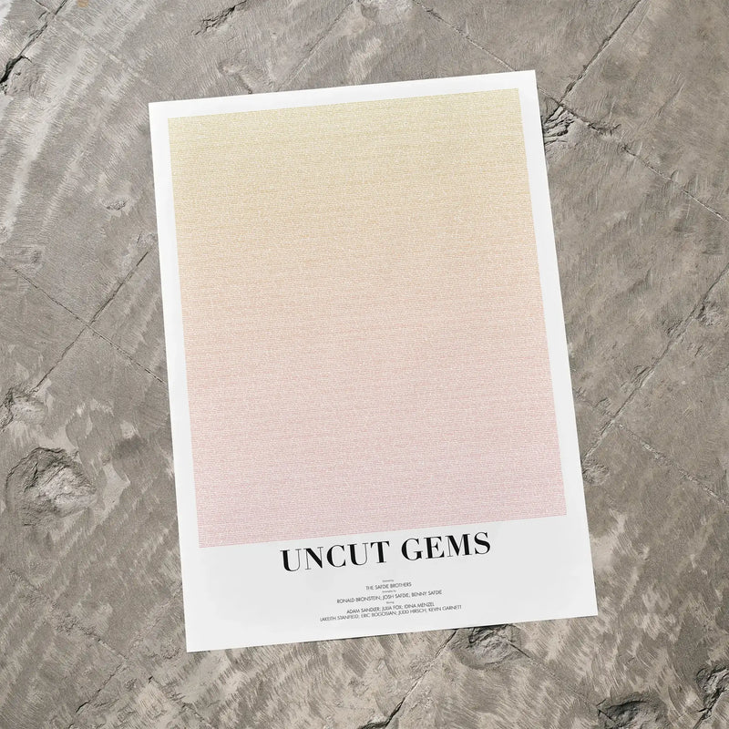 A Uncut Gems movie script poster laid flat on a textured floor surface.