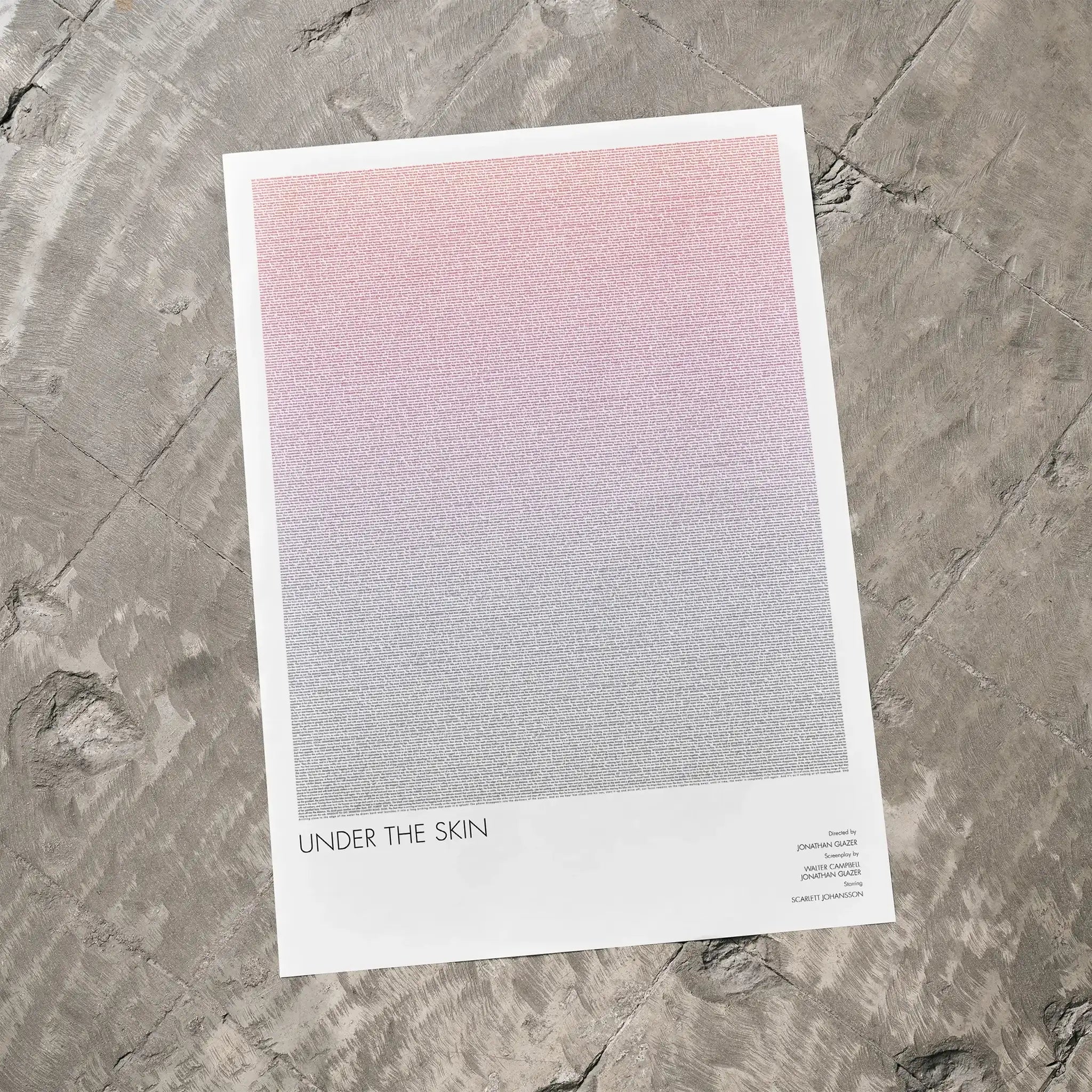 A Under the Skin movie script poster laid flat on a textured floor surface.