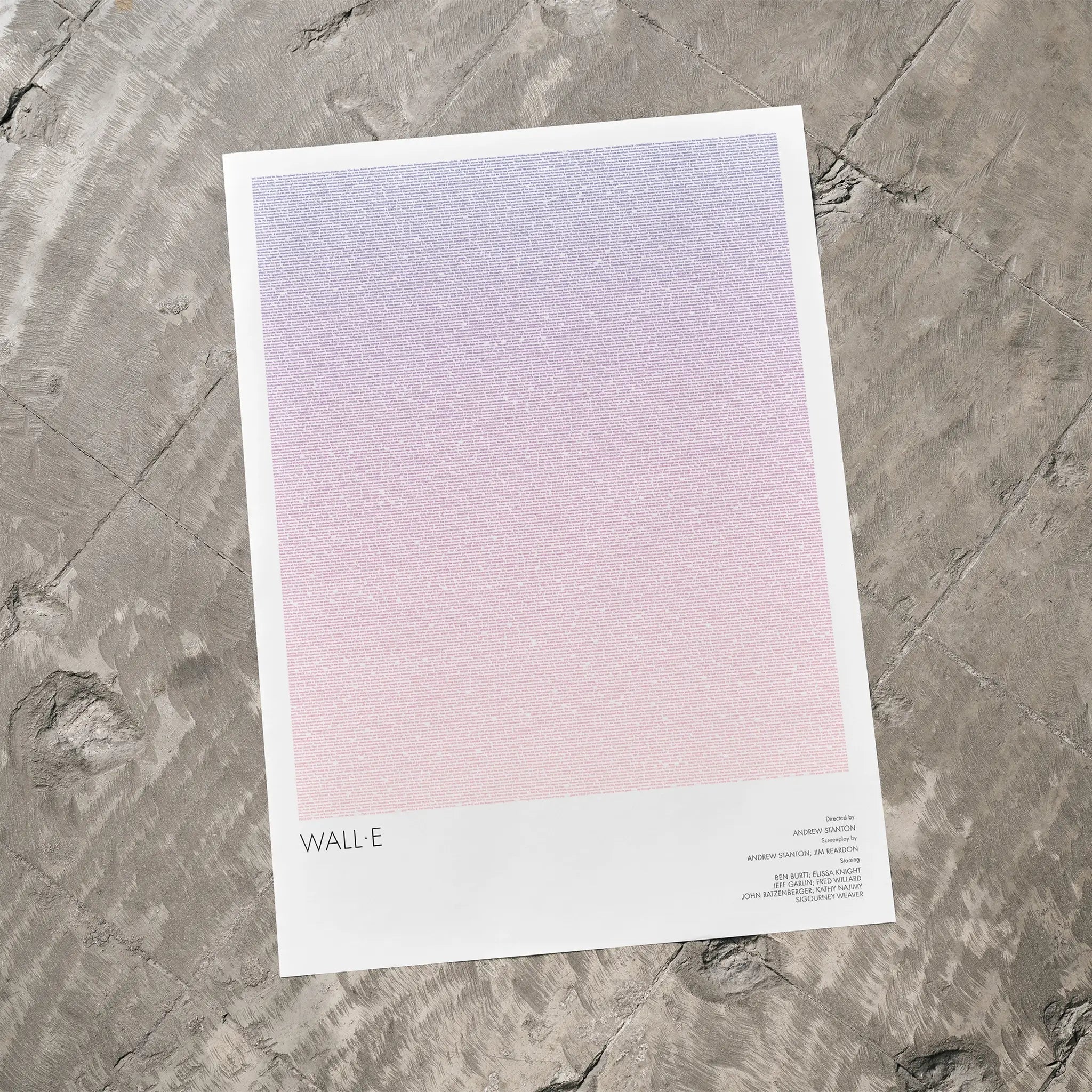 A WALL·E movie script poster laid flat on a textured floor surface.