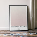 A framed When Harry Met Sally movie script poster leaning against a wall in a minimalist interior.