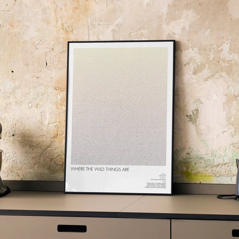 A framed Where the Wild Things Are movie script poster displayed on a cabinet in a minimalist interior.
