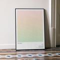 A framed Wicked movie script poster leaning against a wall in a minimalist interior.