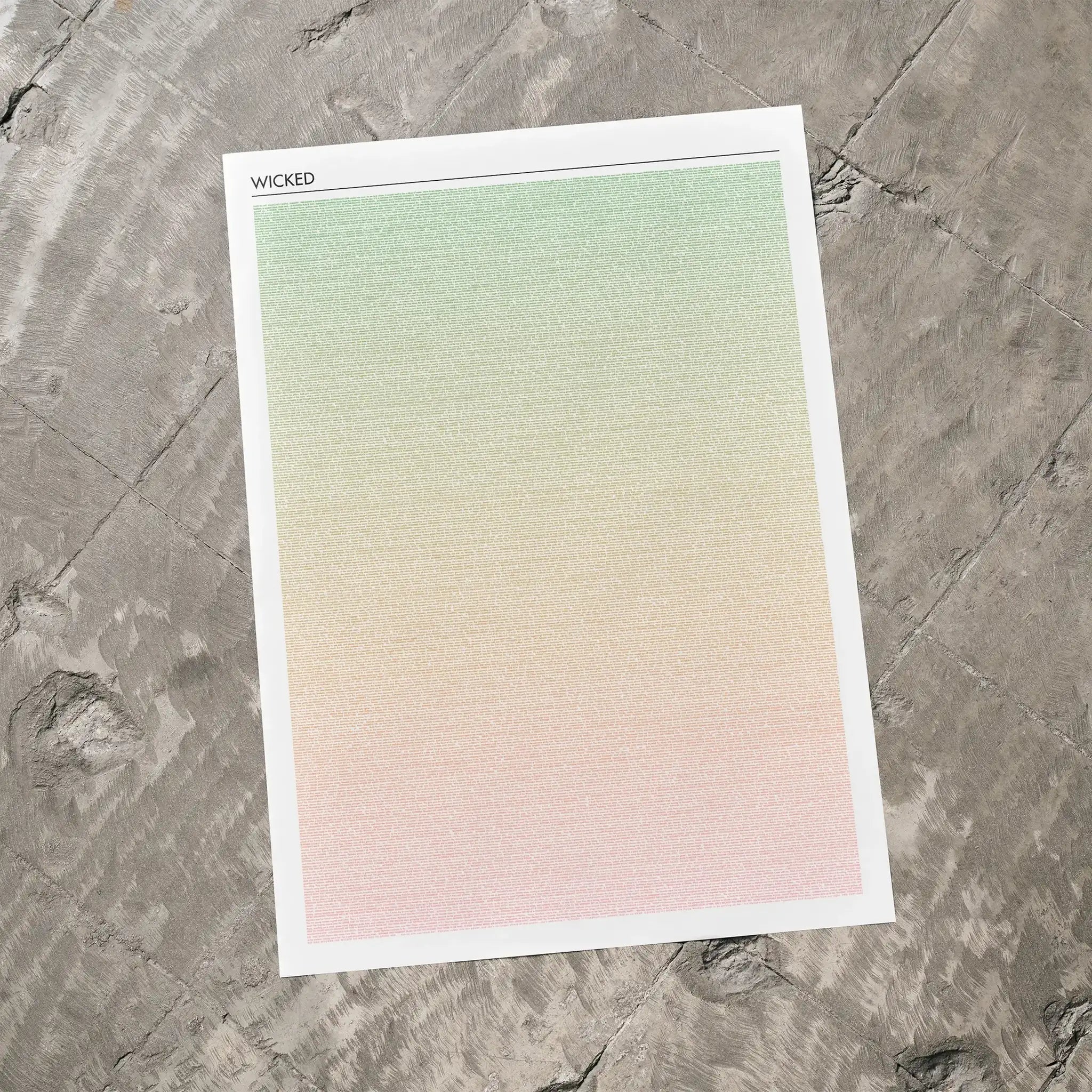 A Wicked movie script poster laid flat on a textured floor surface.