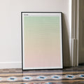 A framed Wicked movie script poster leaning against a wall in a minimalist interior.