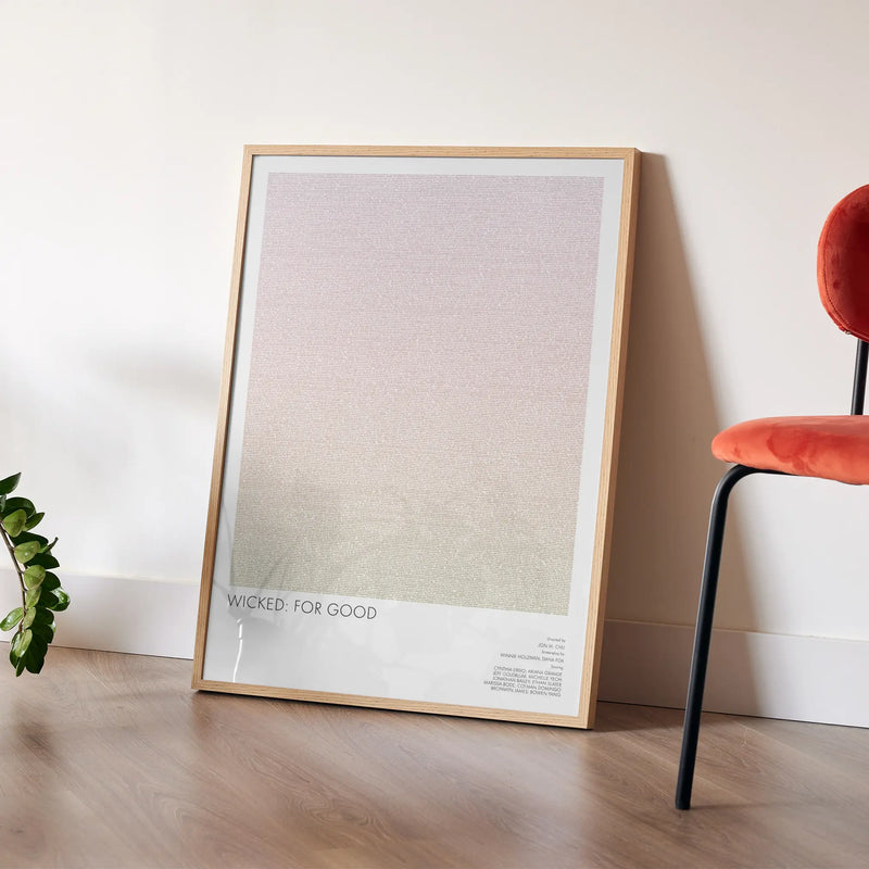 A framed Wicked for Good movie script poster leaning against a wall in a modern interior.